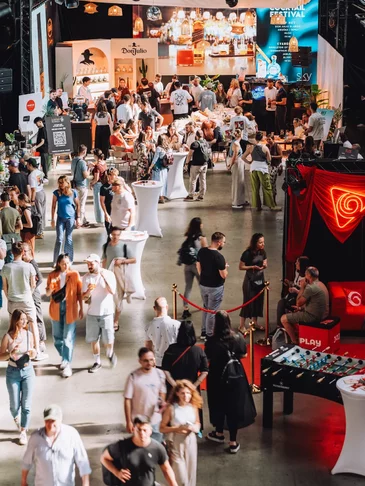 Profesionálna príprava kávy s papierovými pohármi s potlačou na Two Coffee Champs festivale Barista pripravuje kávu na Two Coffee Champs festivale s papierovými pohármi s potlačou na stole